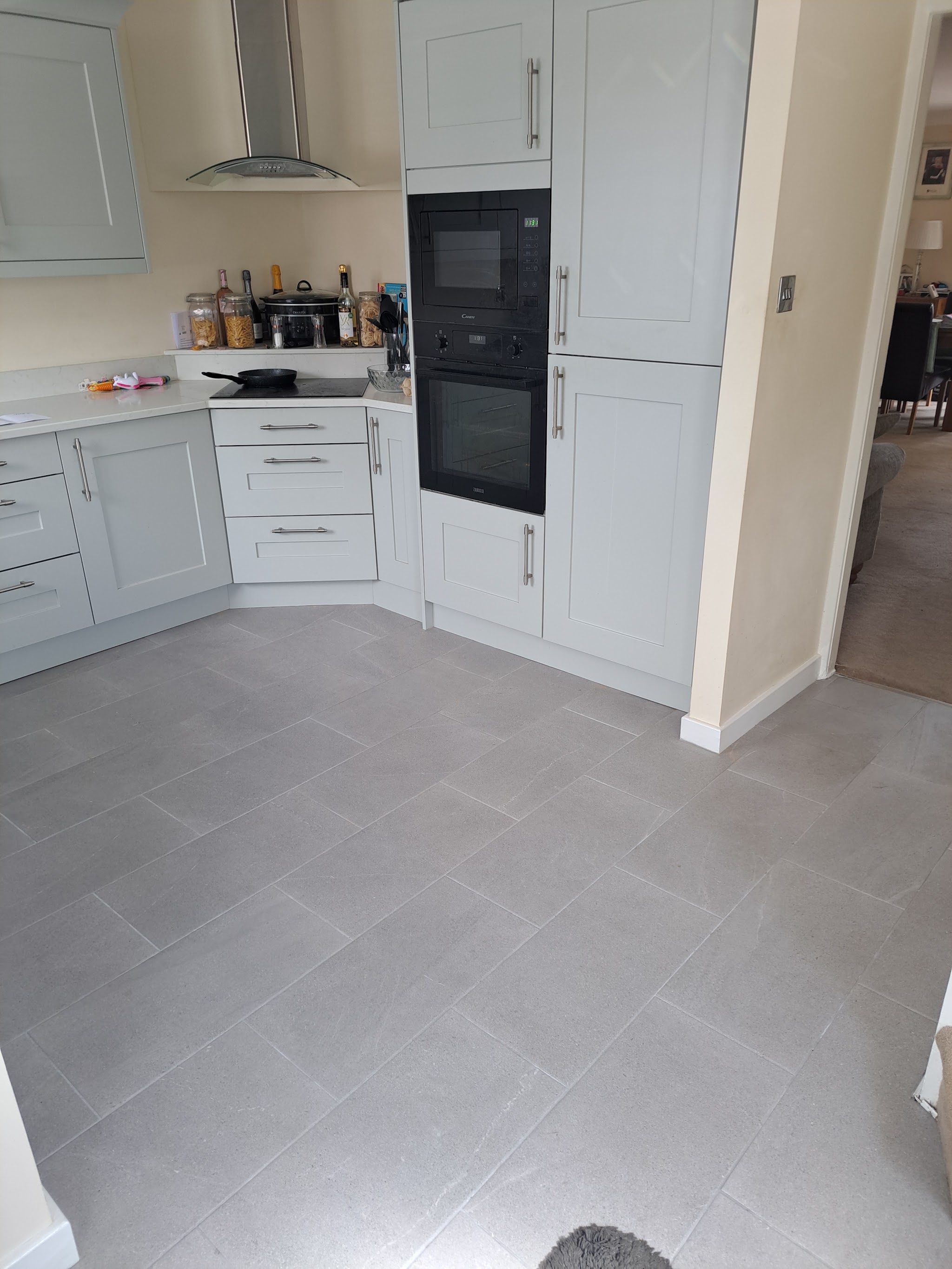 Kitchen with large grey floor tiles running to the units