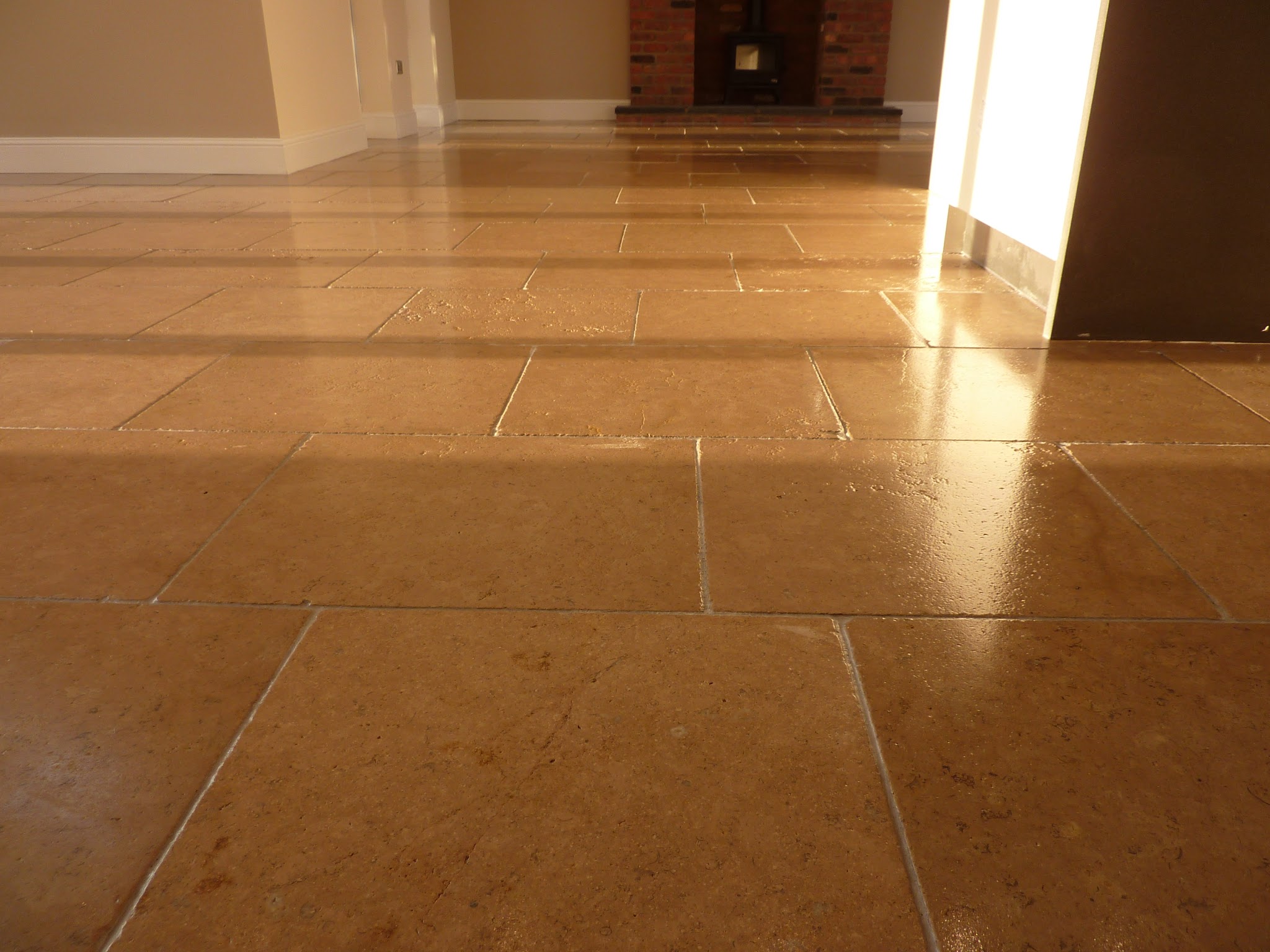 Polished honey-coloured stone floor catching the light from a doorway