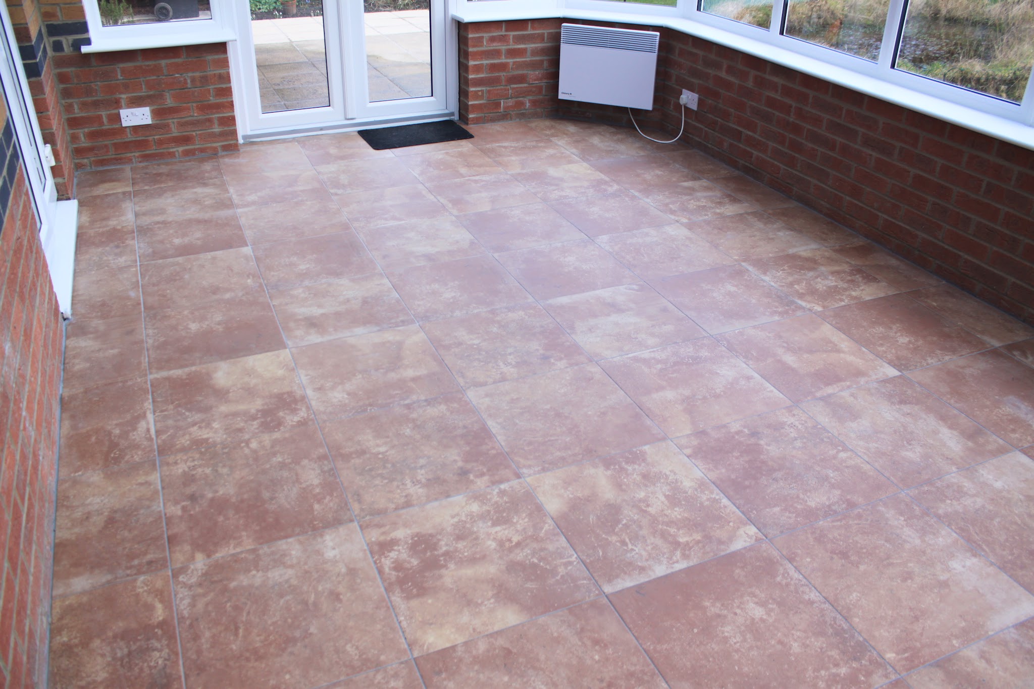 Terracotta-toned floor tiles throughout a conservatory