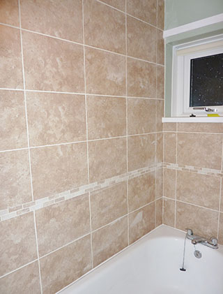 Beige wall tiles around a bath