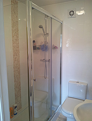 Shower cubicle with cream wall tiles
