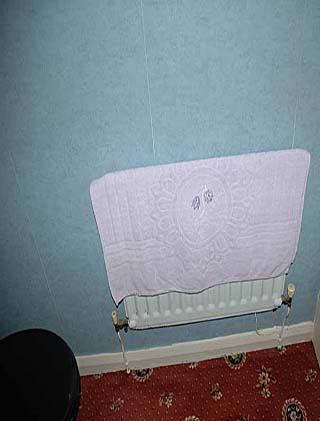 Old radiator and wall covering before the re-fit