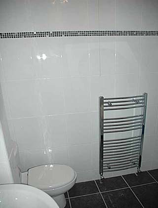 Chrome towel radiator and new dark floor tiles