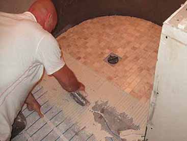 Mosaic tiles being laid on the shower floor