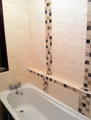 Bath wall with vertical mosaic feature strips