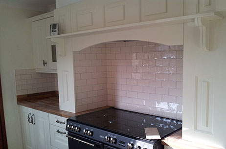 The same white brick-pattern tiles grouted around a range cooker