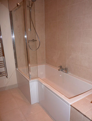 Shower bath with travertine-effect wall tiles