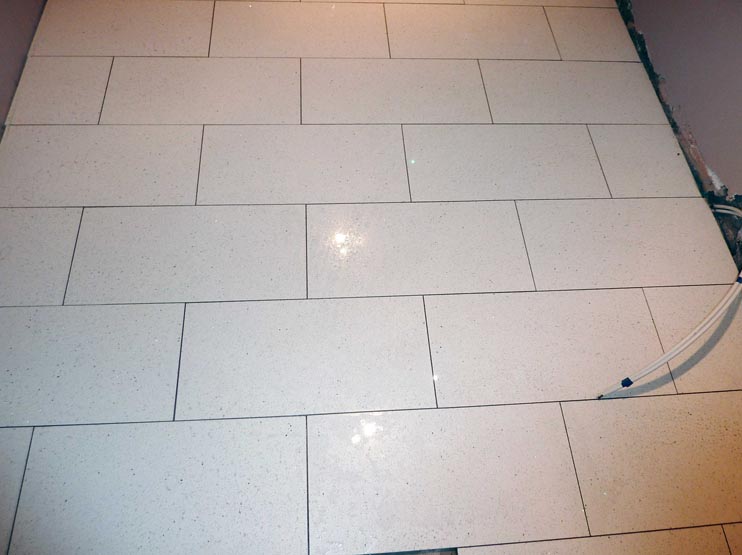 White quartz floor tiles laid in a staggered pattern