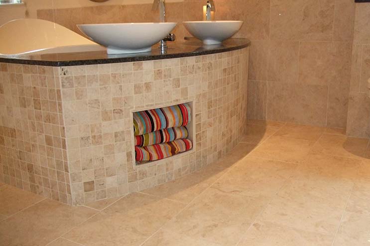 Polished marble floor beneath a curved mosaic vanity