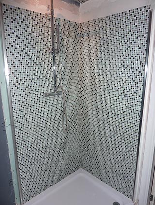 Shower cubicle tiled in black and white mosaic